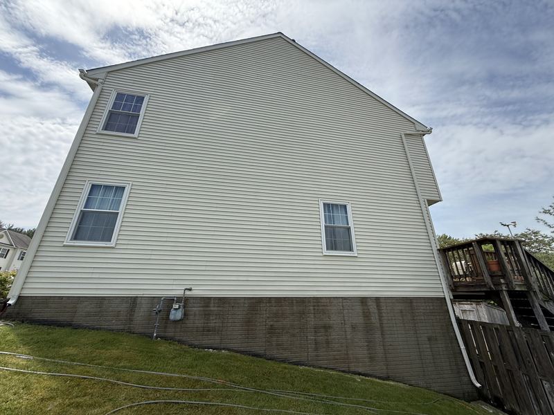 The same Frederick, MD vinyl siding rinsed clean and uniform after low-pressure house soft washing