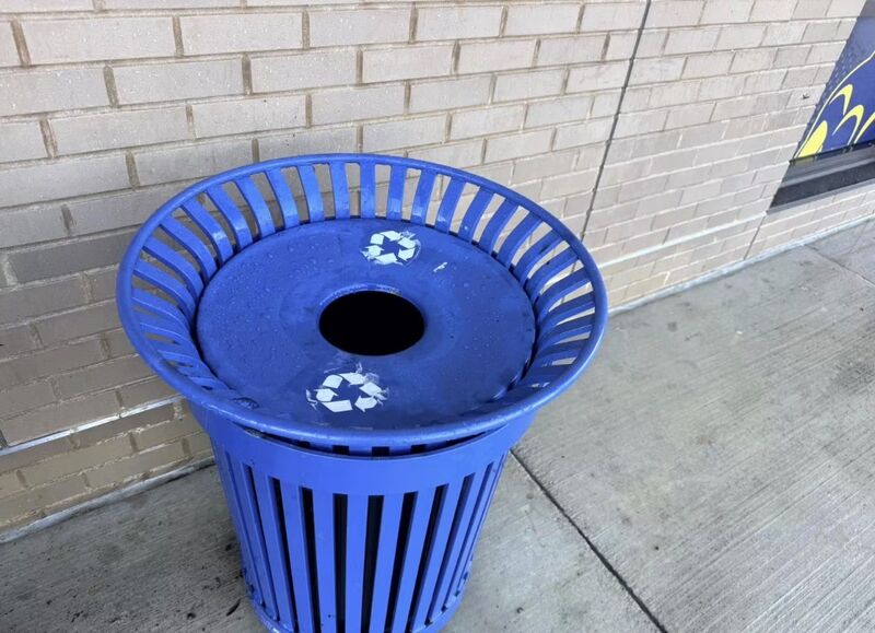 Blue metal recycling receptacle with a clean lid and legible white recycling symbols
