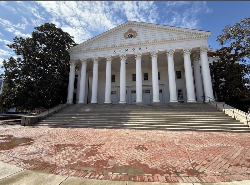 Large columned institutional building with a brick plaza and wide stone steps in front of it