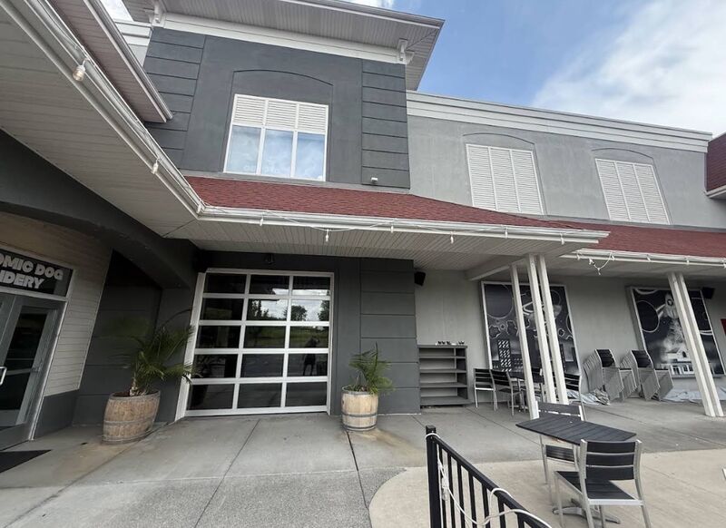 Side elevation of a restaurant property with cleaned concrete patio, planters and a service entry