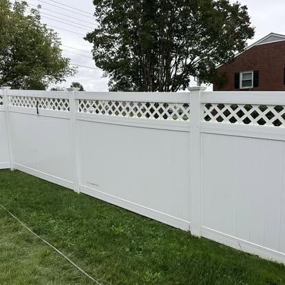 White vinyl fence panel spotted with black mold and green algae growth before cleaning